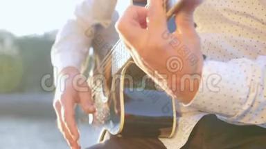 男人手弹吉他。 吉他手触摸吉他弦。 近距离射击。